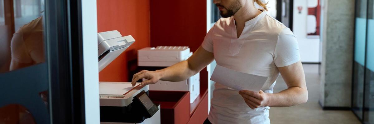 man operating multifunction printer