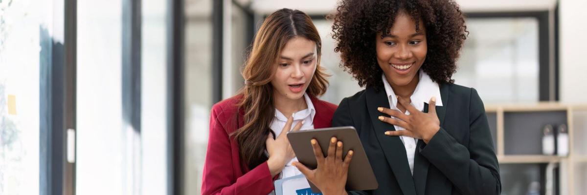 Two business women looking at tablet in surprise